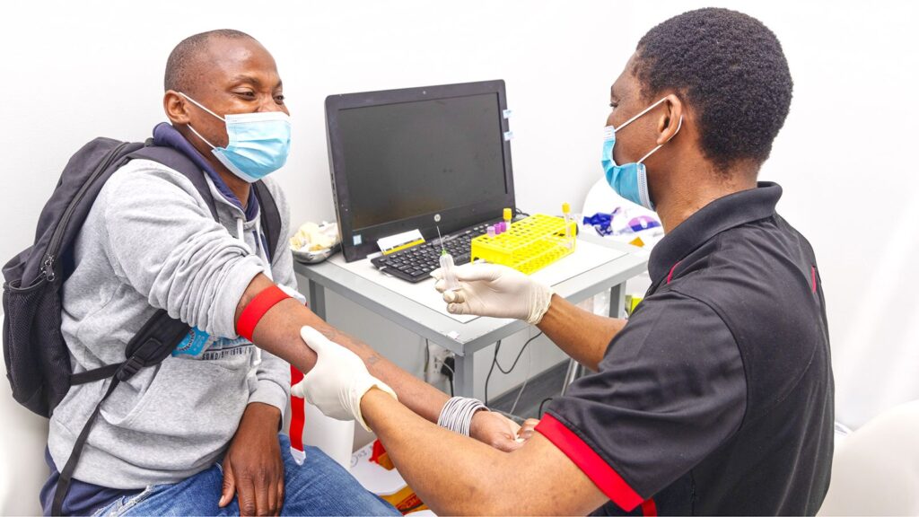 Kabelo Mabeleng prepares Duglas Netshidzivhani for a vaccine trial at the Aurum Institute Rustenberg, South Africa, in August 2022. 