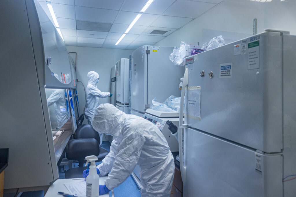 IAVI DDL scientists in hazmat suits work in a laboratory