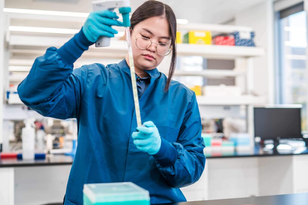 IAVI scientist at the NAC working with lab equipment