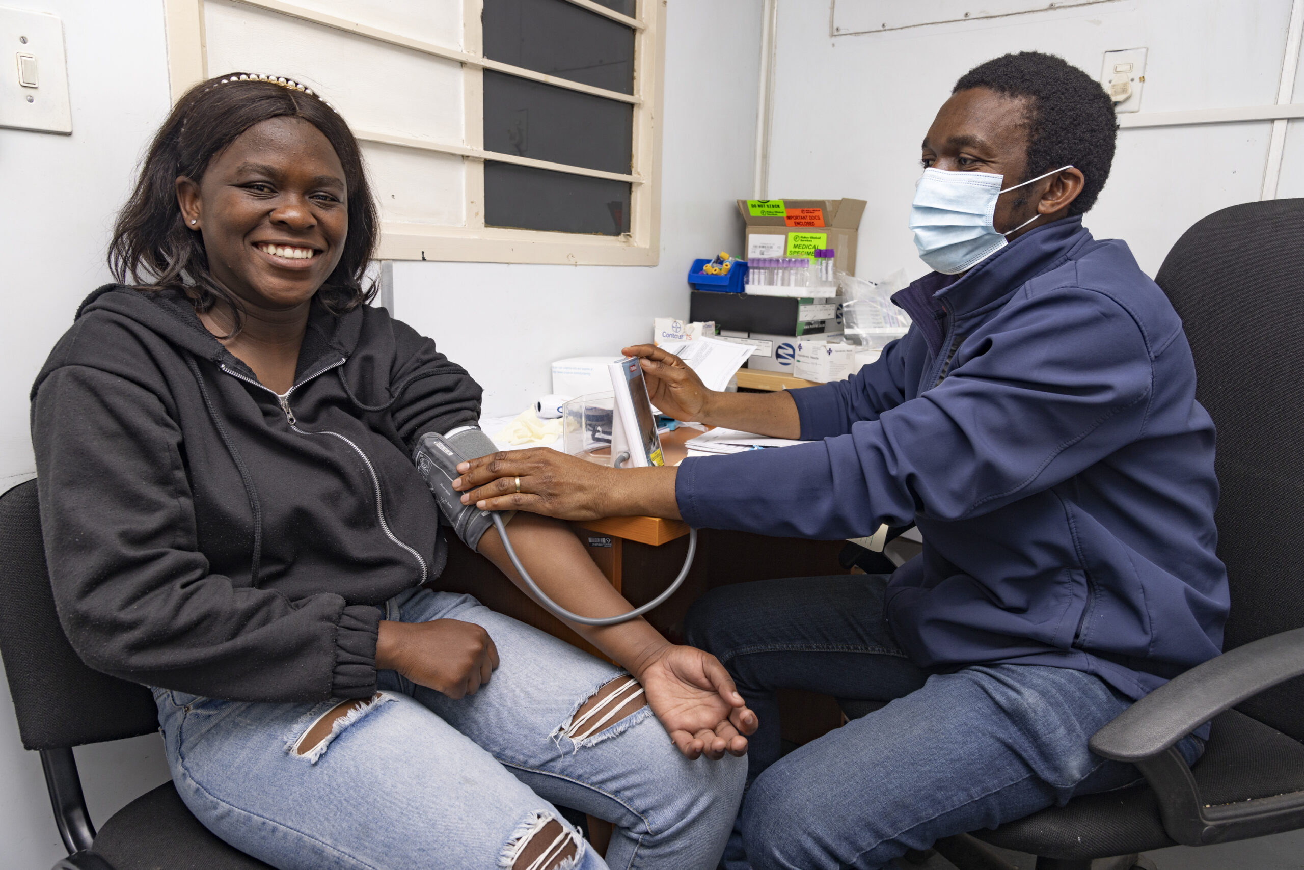 Manase Mapendere checking Nokutula Zimba's blood pressure at Aurum Institute in Tembisa, South Africa on 24th August 2022